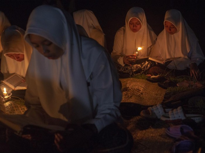 Sejumlah santri membaca Al Quran dengan penerangan sentir di Pondok Pesantren Nurul Hidayah Al Mubarokah, Andong, Boyolali, Jawa Tengah, Minggu (31/3/2024). Kegiatan mengaji tersebut untuk memperingati turunnya Al Quran atau Lailatul Qadar pada bulan Ramadhan serta untuk mendidik santri rajin membaca Al Quran. ANTARA FOTO/Aloysius Jarot Nugroho/YU