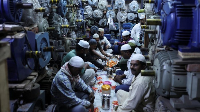Momen Kebersamaan Pedagang India Bukber di Tengah Toko Muslims pray before they eat their Iftar (breaking of fast) meal at a shop during the fasting month of Ramadan in the old quarters of Delhi, India, March 29, 2024. REUTERS/Anushree Fadnavis