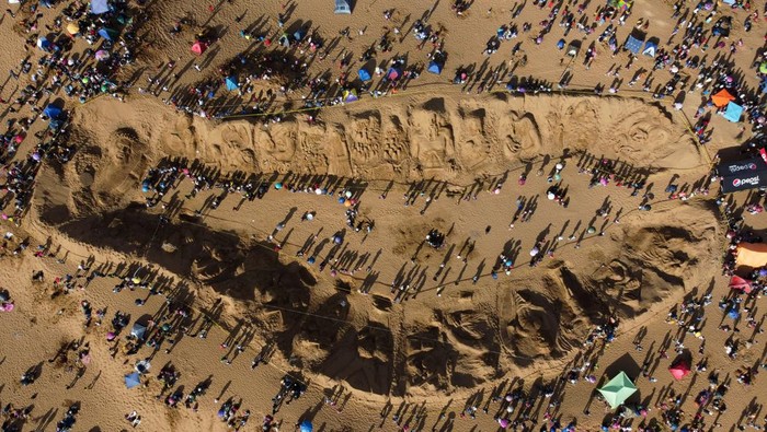 Plastic artists walk near a sand sculpture representing biblical passages during Holy Week celebrations in the Arenal de Cochiraya, on the outskirts of Oruro, Bolivia March 29, 2024. REUTERS/Claudia Morales     TPX IMAGES OF THE DAY