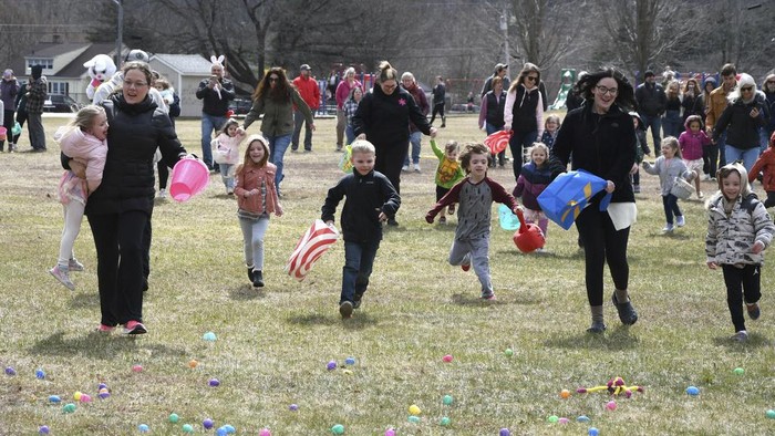 Kids race to pick up eggs at the annual Easter egg hunt sponsored by the Cheshire Police Association, Sunday March 31, 2024, behind the Community House in Cheshire, Mass. The four races, which were determined by age groups, included toddler to age 4, ages 5 to 7, ages 8 to 10, and adults. (Gillian Jones-Heck/The Berkshire Eagle via AP)