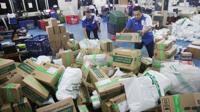 Potret Sibuknya Pengiriman Barang Jelang Lebaran Pekerja melakukan pengepakan barang kiriman logistik di TIKI Pemuda, Jakarta Timur, Senin (1/4/2024).