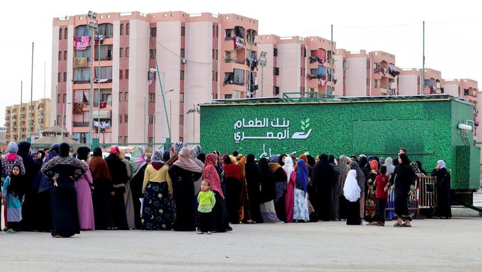 Members of the Egyptian Food Bank give hot meals to fasting public in their mobile kitchen called 