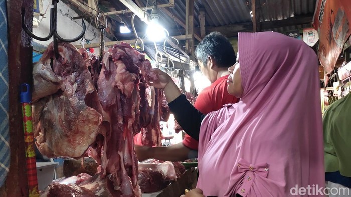 Salah satu pembeli di pasar 26 Ilir sedang memilih daging.