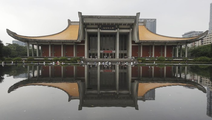 People spend leisure time by a pond near the Sun Yat-sen memorial hall in Taipei, Taiwan, Saturday, March 30, 2024. (AP Photo/Chiang Yiny-ying)