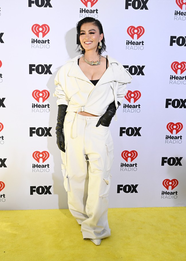 Penyanyi Indonesia Agnez Mo menampilkan gaya edgy dalam nuansa monokrom. Dia memadukan cropped jacket dengan tank-top hitam dan celana cargo oversized. Foto: Getty Images for iHeartRadio/Kevin Mazur