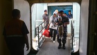 Petugas membantu pemudik saat menaiki Kapal Motor (KM) Kelud di Pelabuhan Bandar Deli Belawan, Medan, Sumatera Utara, Selasa (2/4/2024).
