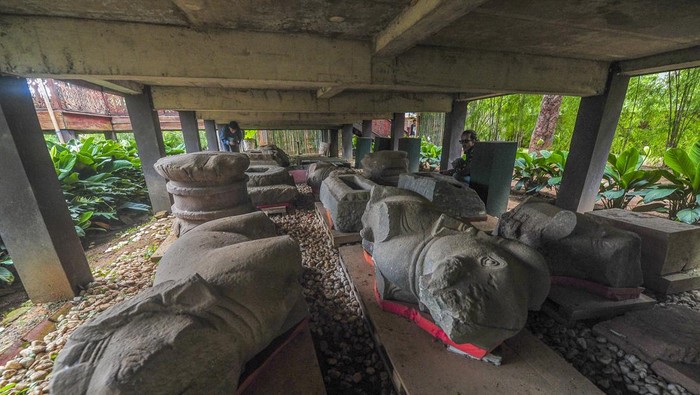 Pengunjung melihat koleksi temuan benda purbakala yang diterlantarkan di bawah bangunan berkonstruksi panggung di Kawasan Candi Kedaton, Kawasan Cagar Budaya Nasional (KCBN) Muara Jambi, Muaro Jambi, Jambi, Senin (1/4/2024). Belasan benda purbakala di antaranya beberapa arca, makara, dan padmasana peninggalan peradaban Candi Muara Jambi yang sebelumnya disimpan di ruang museum setempat kini terlantar di bawah bangunan panggung tanpa penutup selama hampir dua tahun. ANTARA FOTO/Wahdi Septiawan/nym.