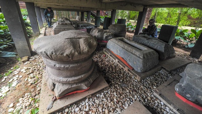 Pengunjung melihat koleksi temuan benda purbakala yang diterlantarkan di bawah bangunan berkonstruksi panggung di Kawasan Candi Kedaton, Kawasan Cagar Budaya Nasional (KCBN) Muara Jambi, Muaro Jambi, Jambi, Senin (1/4/2024). Belasan benda purbakala di antaranya beberapa arca, makara, dan padmasana peninggalan peradaban Candi Muara Jambi yang sebelumnya disimpan di ruang museum setempat kini terlantar di bawah bangunan panggung tanpa penutup selama hampir dua tahun. ANTARA FOTO/Wahdi Septiawan/nym.