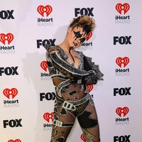 Jojo Siwa muncul dalam balutan catsuit hitam. Busana berbahan menerawang itu memiliki belahan dada yang rendah. Gaya penyanyi 20 tahun itu kian provokatif dengan stoking jaring. Di sisi lain, taburan detail manik-manik menyumbangkan kesan glamor. Foto: Frazer Harrison/Getty Images