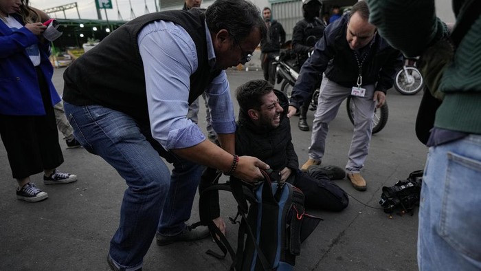 Geger Penembakan Massal di Pasar Chile, 3 Orang Jadi Korban A woman is detained after she grabbed a security guard's weapon and fired it, injuring three people, outside the Lo Valledor wholesale market in Santiago, Chile, Monday, April 1, 2024. The incident occurred while new security measures were being implemented at the market.(AP Photo/Esteban Felix)