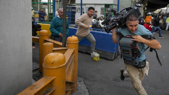 Geger Penembakan Massal di Pasar Chile, 3 Orang Jadi Korban A woman is detained after she grabbed a security guard's weapon and fired it, injuring three people, outside the Lo Valledor wholesale market in Santiago, Chile, Monday, April 1, 2024. The incident occurred while new security measures were being implemented at the market.(AP Photo/Esteban Felix)