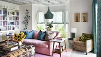 Untuk tempat berkumpul, kamu bisa menggunakan inspirasi seperti ini jika ingin membuat ruangan dengan gaya retro. Dengan sofa dan karpet berwarna pink yang kontras dengan cat warna putih. Bagian langit-langitnya bisa menggunakan hiasan berpola. Foto: K Hayden Rafferty for Dekay and Tate via The Spruce