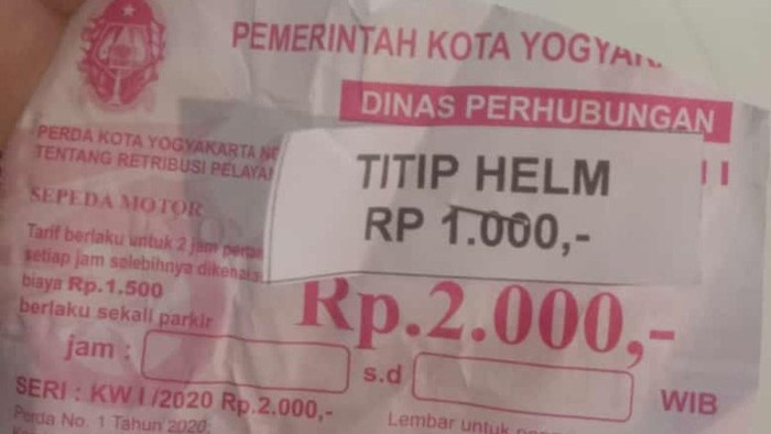 Karcis parkir yang ditempeli karcis penitipan helm di Jogja.