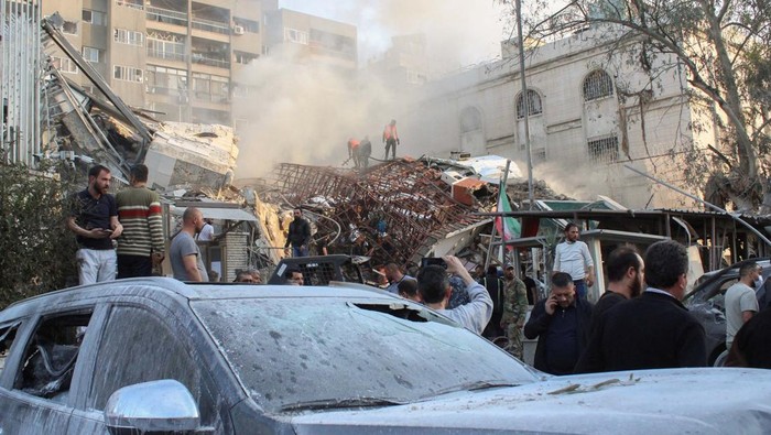People gather near the damaged site after what Syrian and Iranian media described as an Israeli air strike on Irans consulate in the Syrian capital Damascus April 1, 2024. REUTERS/Firas Makdesi