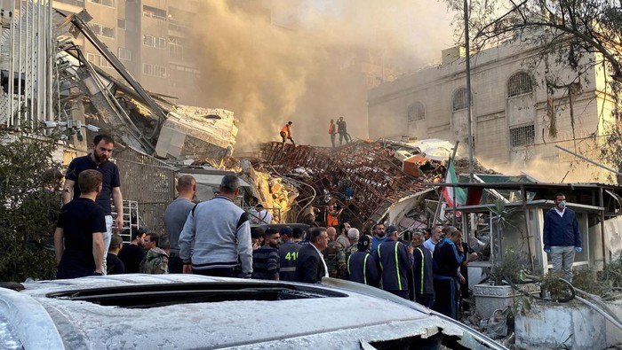 People gather near the damaged site after what Syrian and Iranian media described as an Israeli air strike on Iran's consulate in the Syrian capital Damascus April 1, 2024. REUTERS/Firas Makdesi