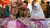 Pj Wali Kota Lhokseumawe A Hanan mencoba menganyam tikar usai membuka pelatihan kerajinan anyaman tikar di Desa Jambo Mesjid, Blang Mangat, Lhokseumawe, Aceh, Selas (2/4/2024).