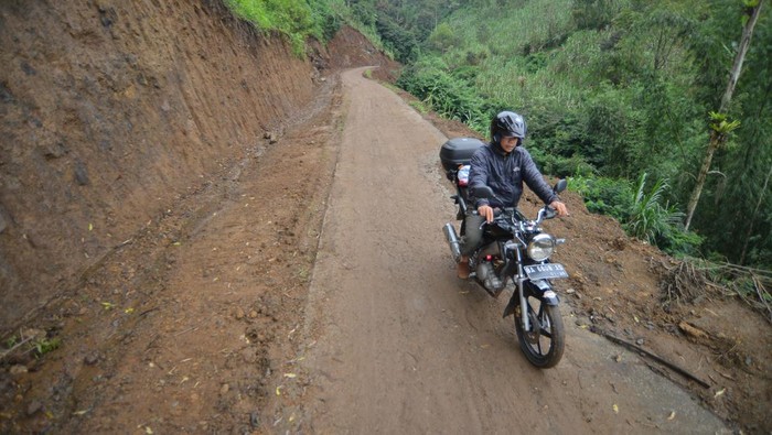 Pengendara melewati jalur evakuasi bencana yang diperlebar di jorong Batang Silasiah, Nagari Bukik Batabuah, Agam, Sumatera Barat, Selasa (2/4/2024). Pemerintah nagari (desa) setempat membenahi 2,5 kilometer jalur evakuasi bencana yang awalnya kecil kemudian diperlebar agar mempermudah evakuasi 933 jiwa yang berada di zona rawan bencana meletusnya Gunung Marapi. ANTARA FOTO/Iggoy el Fitra/Spt.