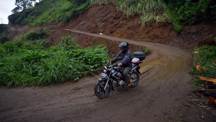 Pembenahan jalur evakuasi bencana Gunung Marapi Pengendara melewati jalur evakuasi bencana yang diperlebar di jorong Batang Silasiah, Nagari Bukik Batabuah, Agam, Sumatera Barat, Selasa (2/4/2024). Pemerintah nagari (desa) setempat membenahi 2,5 kilometer jalur evakuasi bencana yang awalnya kecil kemudian diperlebar agar mempermudah evakuasi 933 jiwa yang berada di zona rawan bencana meletusnya Gunung Marapi. ANTARA FOTO/Iggoy el Fitra/Spt.