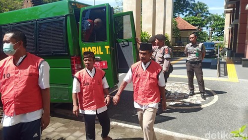 Hadi Sugiarto alias Pak De (61), terdakwa kasus persetubuhan terhadap anak dibawah umur (memakai rompi tahanan paling kanan) saat digiring petugas, Selasa (2/4/2024). (I Putu Adi Budiastrawan/detikBali).