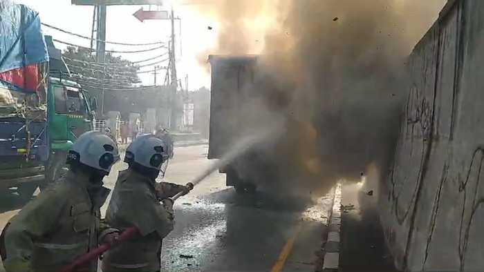 Petugas berusaha memadamkan kebakaran truk ekspedisi di Semarang, Selasa (2/4/2024).