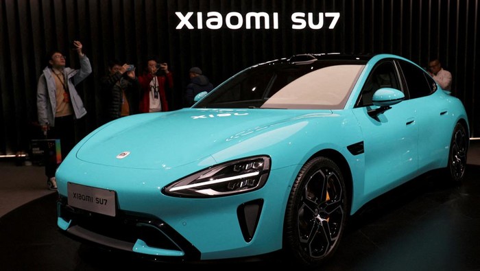 Potret Mobil Listrik Xiaomi SU7, Canggih Lebih Murah dari Tesla FILE PHOTO: Visitors film around Xiaomi's first electric vehicle, the SU7, displayed at an event in Beijing, China December 28, 2023. REUTERS/Florence Lo/File Photo
