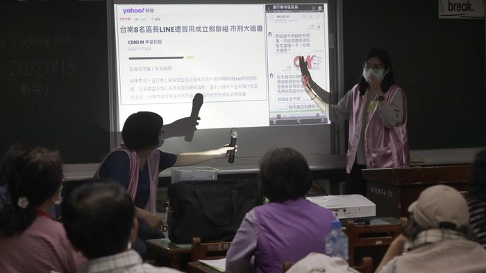 Volunteers of Fake News Cleaner guide students through the LINE app to identify fake news during a class in Kaohsiung City, southern Taiwan, Thursday, March 16, 2023. An anti-misinformation group in Taiwan called Fake News Cleaner has hosted more than 500 events, connecting with college students, elementary-school children — and the seniors that, some say, are the most vulnerable to such efforts. (AP Photo/Chiang Ying-ying)