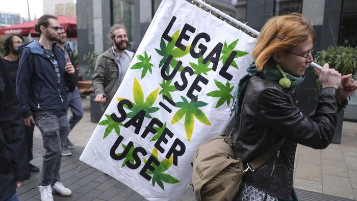 A person holds a banner during a demonstration in favor of the complete legalization of cannabis, in Leipzig, Germany, Monday, April 1, 2024. Marijuana campaigners in Germany lit celebratory joints on Monday as the country liberalized rules on cannabis to allow possession of small amounts. (Sebastian Willnow/dpa via AP)