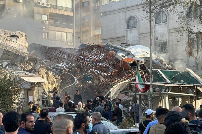 Personel darurat dan keamanan berkumpul di lokasi serangan yang menghantam sebuah gedung di sebelah kedutaan Iran di ibu kota Suriah, Damaskus, pada 1 April 2024. Media pemerintah Suriah mengatakan serangan Israel menghantam gedung konsulat Iran di ibu kota pada 1 April.