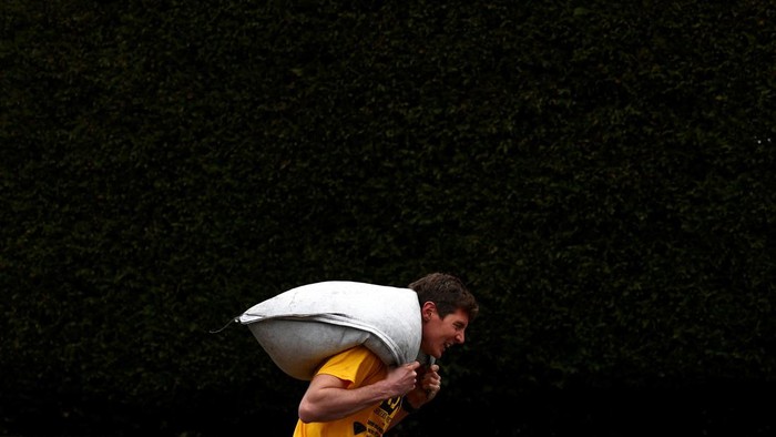 Uniknya Lomba Lari Sambil Pikul Karung Batu Bara di Inggris A male competitor during the World Coal Carrying Championships in Gawthorpe, Britain, April 1, 2024. REUTERS/Lee Smith