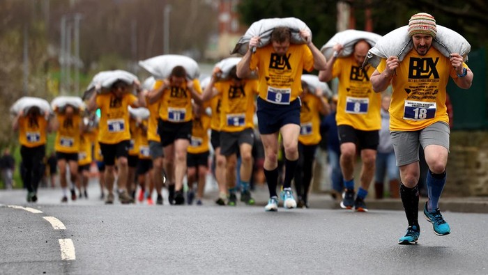 Uniknya Lomba Lari Sambil Pikul Karung Batu Bara di Inggris A male competitor during the World Coal Carrying Championships in Gawthorpe, Britain, April 1, 2024. REUTERS/Lee Smith