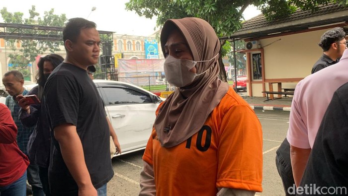 Wanita berinisial DN ditampilkan ke publik usai ditangkap terkait pembunuhan penjaga toko di Tangerang. DN terus menunduk dan terdiam saat dihadirkan polisi. (Taufiq S/detikcom)