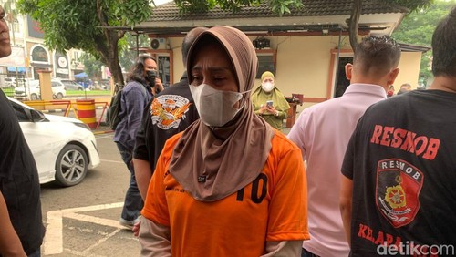 Wanita berinisial DN ditampilkan ke publik usai ditangkap terkait pembunuhan penjaga toko di Tangerang. DN terus menunduk dan terdiam saat dihadirkan polisi. (Taufiq S/detikcom)