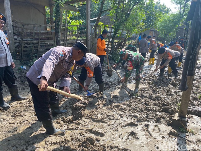 Warga dibantu TNI, Polri hingga petugas BPBD membersihkan sisa lumpur banjir bandang yang menerjang Gunung Panda Madiun