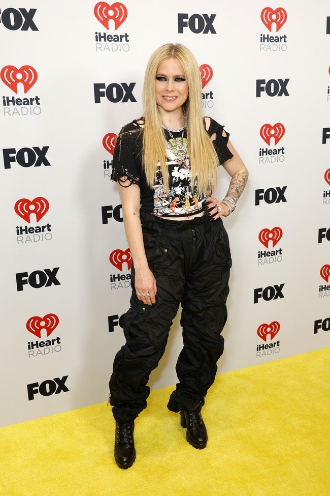 Avril Lavigne bergaya punk rock dengan cropped T-shirt, celana hitam dan boots. Foto: Getty Images/Frazer Harrison