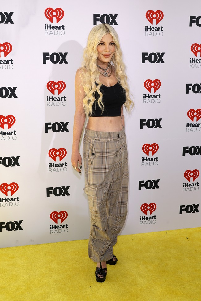 Tori Spelling memilih tampilan casual. Mantan bintang serial ‘Beverly Hills 90210’ ini memakai atasan crop yang mengekspos perut dan celana cargo dipadu platform heels. Foto: Getty Images/Frazer Harrison