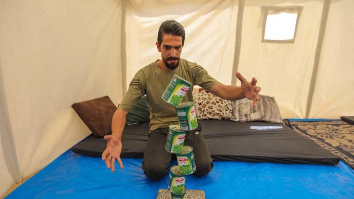Aksi Keren Pemuda Gaza Menyeimbangan Benda RAFAH, GAZA - APRIL 1: A young Palestinian man, Muhammad Al-Shanbari, 28 years old, practices the art of balance and the challenge of gravity on April 1, 2024 in Rafah, Gaza. Muhammad Al-Shanbari, 28, from the city of Beit Hanoun in the northern Gaza Strip, was displaced to the city of Rafah in the southern Gaza Strip during the war. He practices the art of balance in stabilizing various objects through the fulcrum in an artistic manner and defies gravity. (Photo by Ahmad Hasaballah/Getty Images)