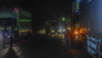 Sejumlah awak truk berdiri di dekat kendaraannya saat terjebak macet di Jalan Lingkar Selatan, Kota Cilegon, Banten, Rabu (3/4/2024). Pengalihan jalur sepeda motor dari Pelabuhan Merak ke Pelabuhan Ciwandan mengakibatkan aktivitas bongkar muat truk di kapal terhambat dan menyebabkan banyak truk terjebak kemacetan lebih dari 12 jam. 