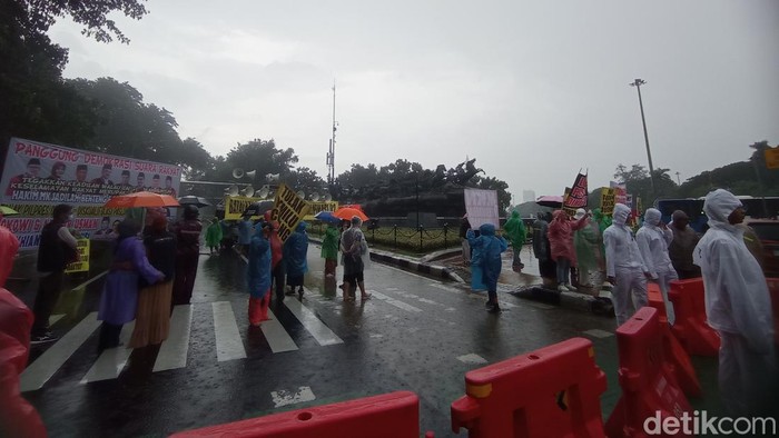 Massa Gelar Aksi Damai di Patung Kuda Jakpus Meski Diguyur Hujan