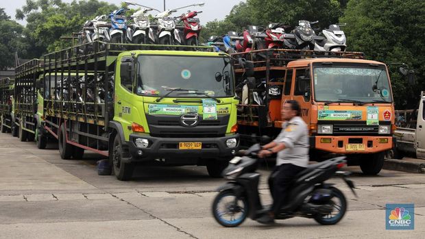 Pekerja mengecek ikatan kendaraan motor yang hendak dikirim melalui jasa pengiriman yang dibuka untuk Mudik Gratis 2024 di Terminal Pulogadung, Jakarta, Rabu (3/4/2024). (CNBC Indonesia/Muhammad Sabki)