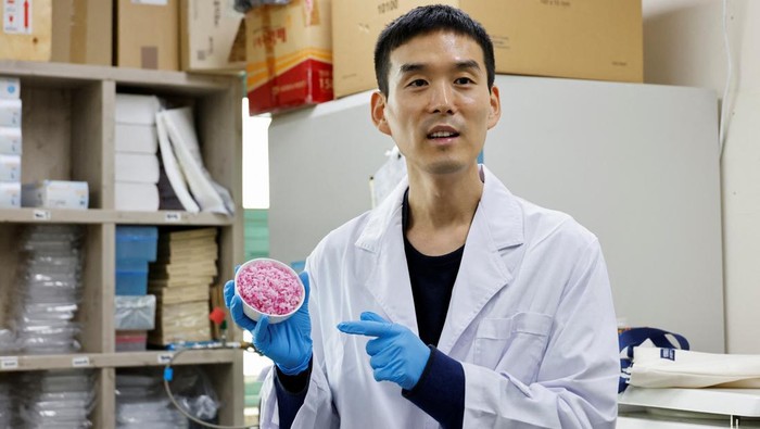 A researcher handles a petri dish containing hybrid beef rice, elaborated using cow muscle and fat stem cells, at the laboratory of Yonsei University in Seoul, South Korea, March 8, 2024. REUTERS/Kim Soo-hyeon