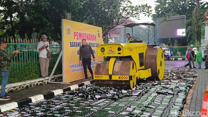 Pihak kepolisian bersama jajaran pemerintah daerah Kabupaten Bogor, Jawa Barat, memusnahkan minuman keras (miras) dan knalpot brong hasil razia (Rizky Adha/detikcom)