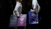 Seorang pria menunjukkan paspor Inggris, Polandia, dan Australia yang berlumuran darah setelah serangan udara Israel, di Deir al-Balah, Jalur Gaza, Senin (1/4/2024). (AP Photo/Abdel Kareem Hana)