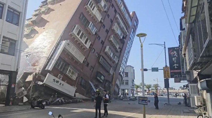 Taiwan Diguncang Gempa Dahsyat, Gedung-gedung Runtuh In this image taken from a video footage run by TVBS, a woman stands near a partially collapsed building in Hualien, eastern Taiwan on Wednesday, April 3, 2024. A powerful earthquake rocked the entire island of Taiwan early Wednesday, collapsing buildings in a city and creating a tsunami that washed ashore on Japanese islands. (TVBS via AP)