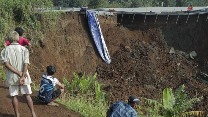 Jalan Tol Bocimi amblas Warga mengamati kondisi jalan tol yang amblas di ruas tol Bocimi KM 64, Sukabumi, Jawa Barat, Kamis (4/4/2024). Jalan tol Bocimi KM 64 yang amblas pada Rabu (3/4) malam tersebut mengakibatkan satu mobil dan dua orang terperosok dan arus lalu lintas dari Jakarta menuju Sukabumi dialihkan ke pintu keluar tol Cigombong. ANTARA FOTO/Henry Purba/agr/nym.