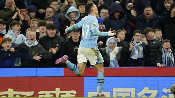 Manchester Citys Phil Foden runs towards the fans as he celebrates after scoring his teams fourth goal and his own third of the match during the English Premier League soccer match between Manchester City and Aston Villa at the Etihad Stadium in Manchester, England, Wednesday, April 3, 2024. (AP Photo/Dave Thompson)