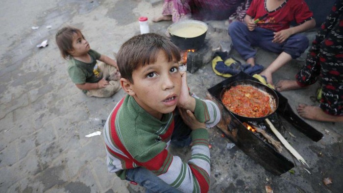 Potret Anak Gaza Menunggu Makanan Berbuka di Tengah Bencana Kelaparan DEIR AL BALAH, GAZA - APRIL 03: Palestinians prepare food for iftar (break fasting meal) during the holy month of Ramadan amid dramatic starvation and hunger due to Israeli blockade in the besieged Gaza Strip on April 03, 2024. (Photo by Ashraf Amra/Anadolu via Getty Images)