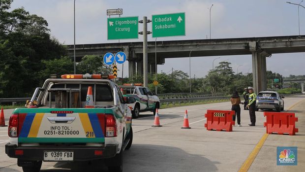 Sejumlah petugas betugas berjaga mengalihkan jalan tol di exit tol Bogor Ciawi, Jawa Barat, Kamis, (4/4/2024). Akses exit tol ditutup dari arah Jakarta ke Sukabumi maupun sebaliknya. (CNBC Indonesia/Muhammad Sabki)