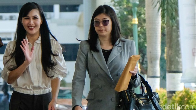 Ibu dua anak ini muncul dalam balutan blus putih dengan celana berpotongan lebar. Atasan tersebut berlengan pendek yang mengekspos bekas infus di lengan kiri Sandra. Ia dirawat di rumah sakit saat suaminya diumumkan sebagai tersangka. (Foto: Andhika Prasetia)