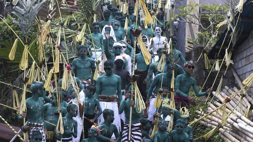 Body-painted men parade as they participate in the Hindu ritual of Ngerebeg at Tegallalang village in Bali, Indonesia on Wednesday, April 3, 2024. In this ritual, participants paint their bodies with colorful paint and parade around their village to ward off evil spirits and bring happiness to the village. (AP Photo/Firdia Lisnawati)