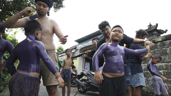 Body-painted men parade as they participate in the Hindu ritual of Ngerebeg at Tegallalang village in Bali, Indonesia on Wednesday, April 3, 2024. In this ritual, participants paint their bodies with colorful paint and parade around their village to ward off evil spirits and bring happiness to the village. (AP Photo/Firdia Lisnawati)